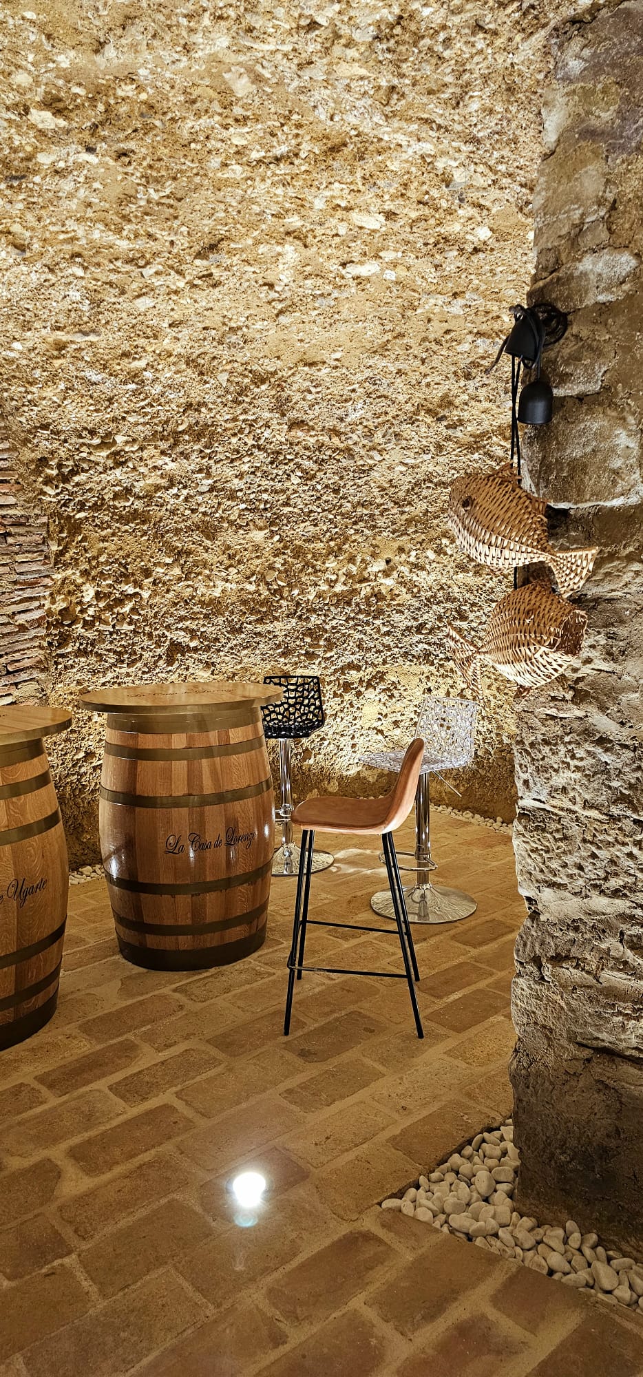 legado de ugarte alojamientos rurales bodega cueva mesas barrica laguardia - Legado de Ugarte ofrece casas rurales y apartamentos con encanto en Laguardia, corazón de la Rioja Alavesa. Dispones de casa rural por habitaciones en la Calle Mayor y alojamientos de alquiler íntegro con jardín y barbacoa, ideales para parejas, familias y grupos que quieren disfrutar de enoturismo y del casco histórico medieval. Habitaciones y apartamentos amplios, con baño privado, WiFi y todas las comodidades para una estancia tranquila entre viñedos. Tu alojamiento rural en Laguardia para conocer bodegas, rutas del vino y los pueblos más bonitos de Rioja Alavesa. Zona tipo bodega cueva de piedra con mesas de barrica y taburetes altos.